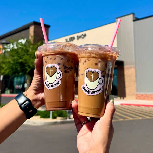 Custom Daily Brew logo stickers on two iced coffee cups